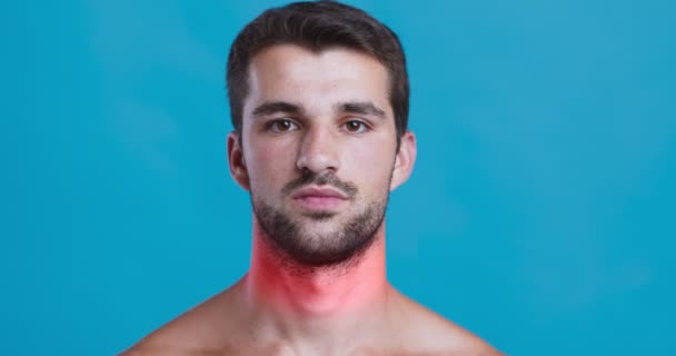 Stúdió portré fiatal férfi piros gyulladt nyak, kék háttér — Stock videók