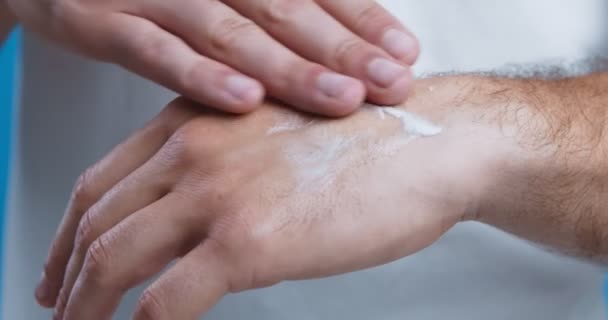 Man moisturizing dry skin of his hands, eczema prevention, close up — Stock Video