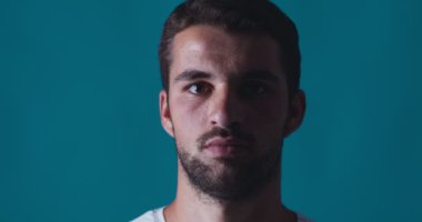 Kapsülü yüzünün önünde tutan genç adamın portresi.
