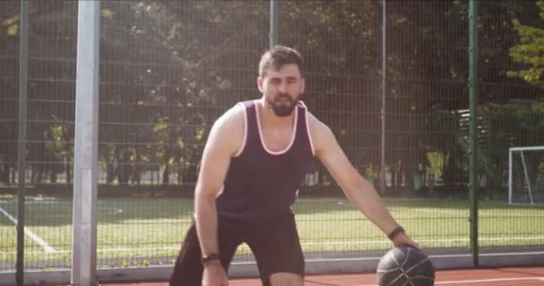 Игрок пов на молодого кавказца капает мяч и бежит к обручу — стоковое видео