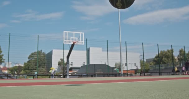 Zwarte bal stuiteren op outdoor basketbalveld — Stockvideo