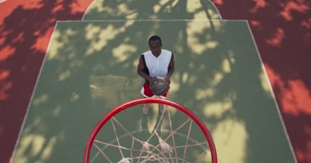 Professionele Afrikaanse amerikaanse basketbalspeler gooien bal in hoepel — Stockvideo