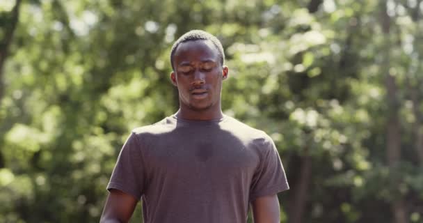 Surriscaldato africano americano ragazzo bere acqua da bottiglia in parco — Video Stock