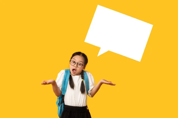 Schoolgirl Posing With Empty Speech Bubble Above Head, Yellow Background — Stok Foto