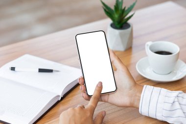 İş yerinde akıllı telefonunu kullanan üst düzey bir kadın.