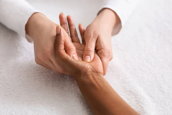 Relaxing hand massage for unrecognizable african lady — Stock Photo, Image