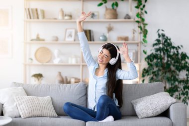 Müzik aşığı. Kulaklıklı neşeli Asyalı Kız En sevdiği şarkıları dinlemekten zevk alıyor.