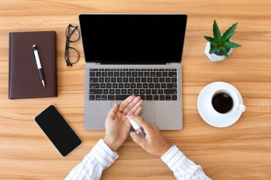 Ellerini dezenfekte etmek için antiseptik sprey kullanan bir kadın.