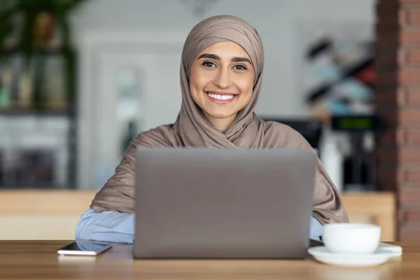 Kafede çalışan tesettürlü neşeli Müslüman kadın. — Stok fotoğraf