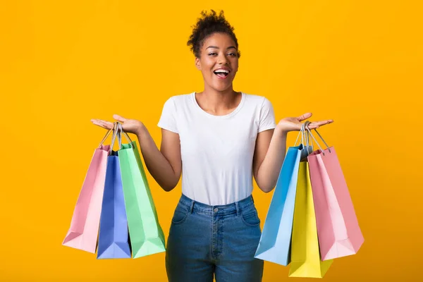 Retrato de alegre senhora negra segurando sacos de compras — Fotografia de Stock