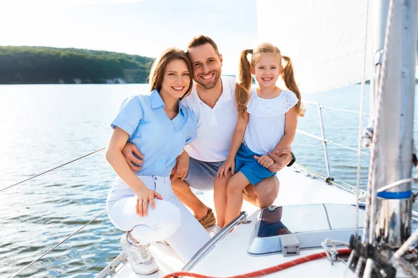 Joyeuse famille de trois posant souriant à la caméra sur le yacht — Photo