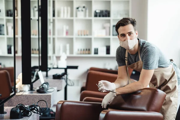 Cheerful beauty master in protective mask waiting for clients at empty salon — Stock Photo, Image