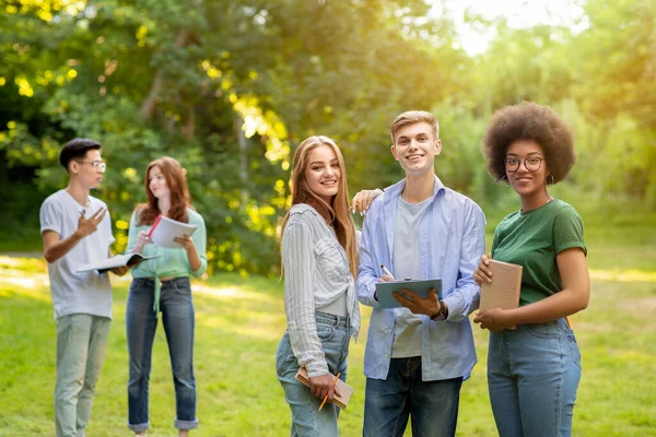 Groupe d'étudiants multiethniques se reposant entre les classes à l'extérieur sur le campus — Photo