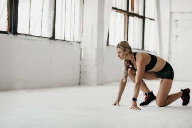 Spor salonunda çalışmaya başla. Spor kıyafetli kaslı kadın spor salonunda spor yapıyor.