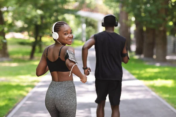 Koncepcja wellness. Uśmiechnięta Afrykanka biegająca ze swoim chłopakiem w City Parku — Zdjęcie stockowe