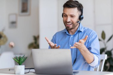 Web Konferansı. Kulaklıklı İşadamı, Ortaklar Aracı Bilgisayarı ile Video Görüşmesi Yapıyor