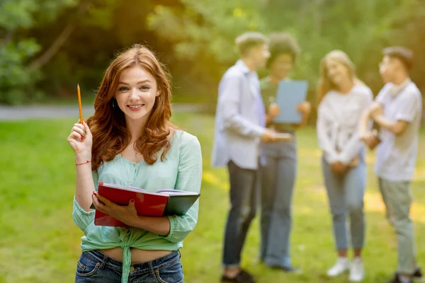 Bildungskonzept. Hübsch nerdy student und gruppe von sie classmates outdoor — Stockfoto