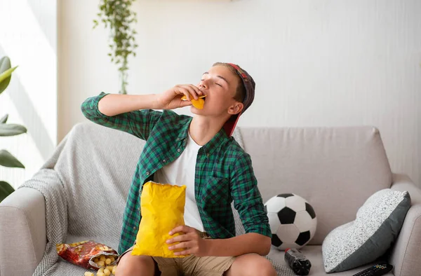 Adolescent guy appréciant jetons tout en regardant football jeu — Photo