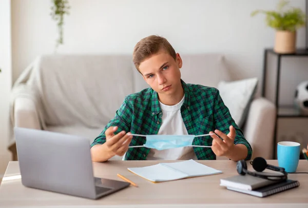 Gelangweilte Schüler mit Schutzmaske, die von zu Hause lernen — Stockfoto