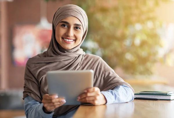 Chica feliz en hijab con tableta digital sonriendo a la cámara — Foto de Stock