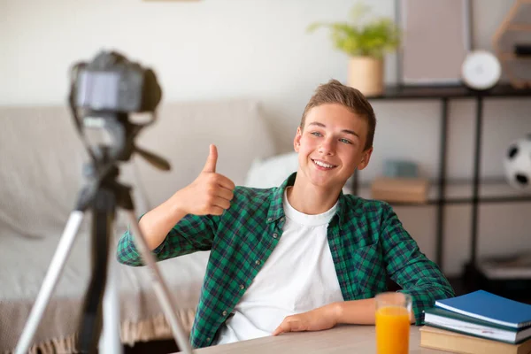 Fröhlicher Teenager zeigt Daumen hoch und sendet von zu Hause aus — Stockfoto