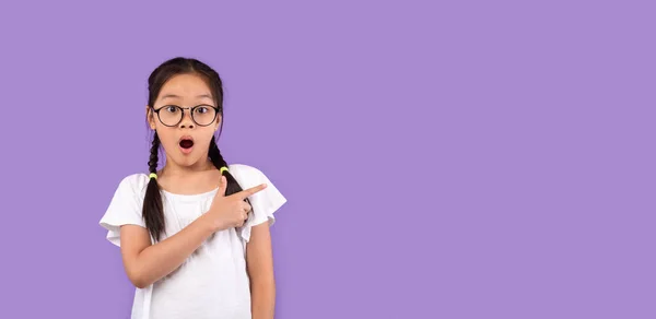 Shocked Japanese Girl Pointing Finger Aside On Purple Background, Panorama — Stock Photo, Image