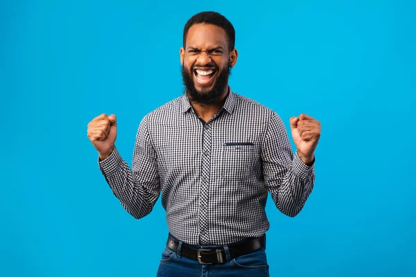 Щасливий афро-чоловік тріумфує з піднятими руками — стокове фото