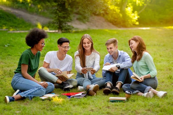 Campus Pastime. Estudantes universitários alegres descansando ao ar livre com smartphone, assistindo vídeos — Fotografia de Stock