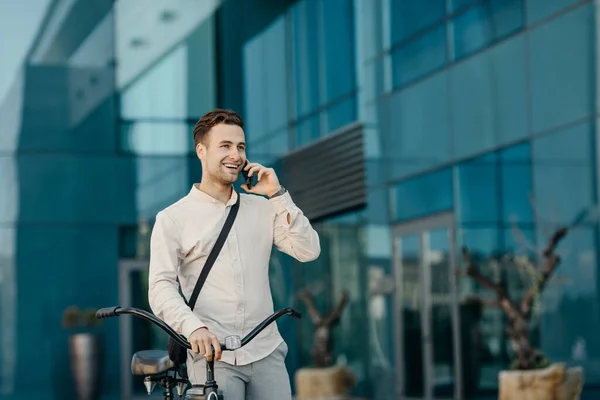 Biznesmen z transportu miejskiego. Portret mężczyzny z telefonem, w pobliżu nowoczesnego biurowca — Zdjęcie stockowe