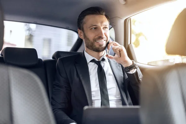 Lycklig framgångsrik affärsman talar i telefon i bilen — Stockfoto