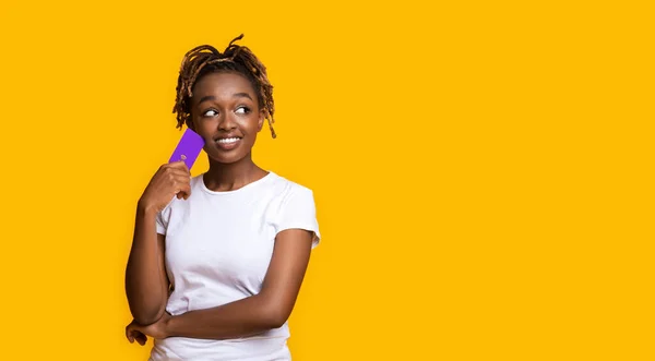 Menina interessada com cartão de crédito olhando para o espaço de cópia — Fotografia de Stock