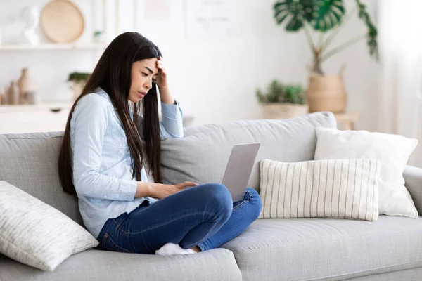 Moe aziatische meisje freelancer met behulp van laptop thuis, met afstandsbediening stress — Stockfoto