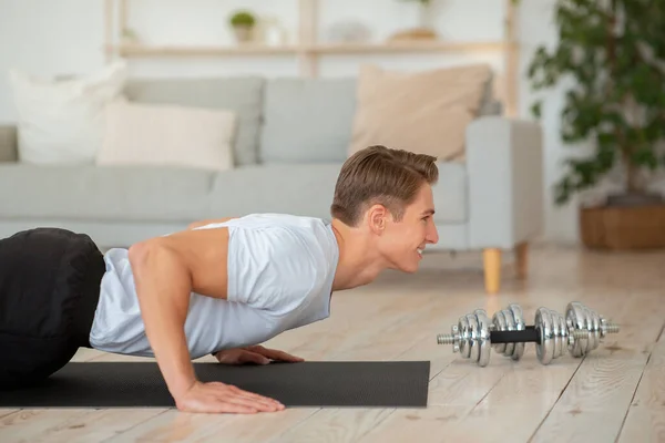 Corpo bonito e esporte em casa. Cara fazendo flexões no chão da sala — Fotografia de Stock