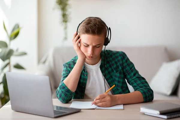 Sério adolescente cara estudando online a partir de casa — Fotografia de Stock