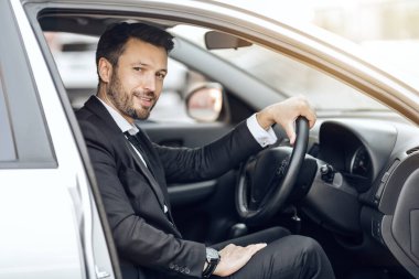 Mutlu genç girişimci arabada oturuyor, ofise gidiyor.