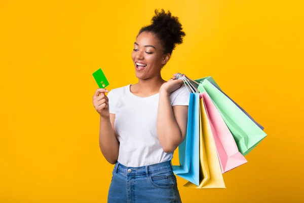 ショッピングバッグやプラスチックカードと陽気なアフロ女性 — ストック写真