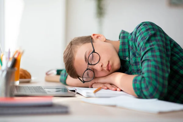 Niño agotado en gafas durmiendo en el escritorio —  Fotos de Stock