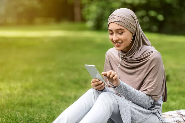 Boldog arab nő fülhallgatóval mobiltelefonnal — Stock Fotó