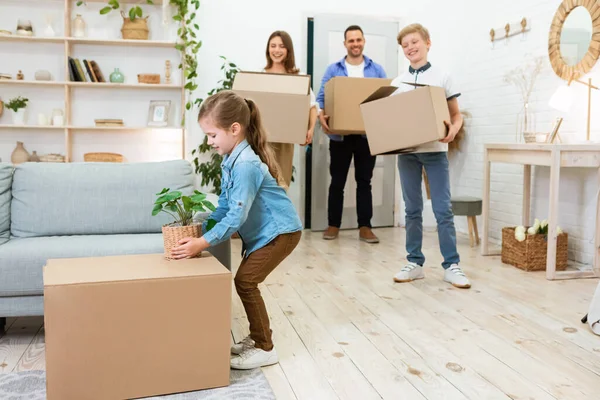 Família com crianças movendo-se casa desempacotando caixas em novo apartamento — Fotografia de Stock