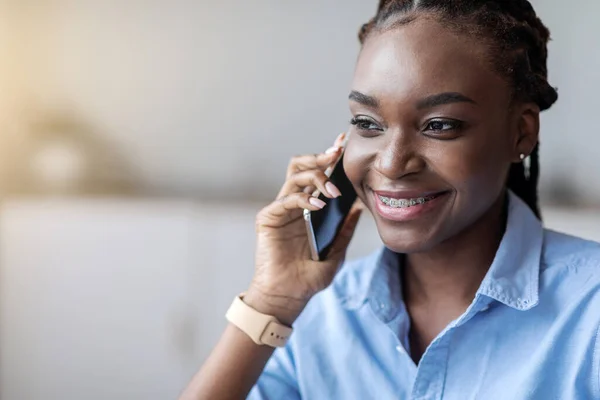 Llamada telefónica. Sonriente mujer afroamericana con frenos hablando por celular —  Fotos de Stock