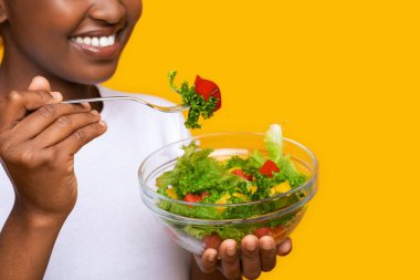 Sebze salatasının tadını çıkaran Afrikalı kadının yakın çekimi.