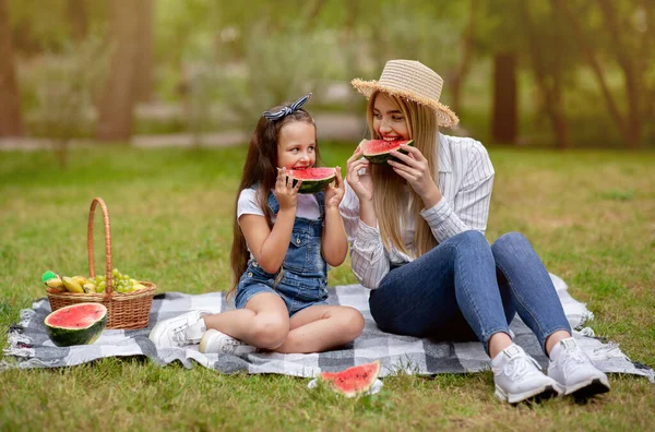 Máma a dcera těší rodinný piknik jíst meloun v parku — Stock fotografie