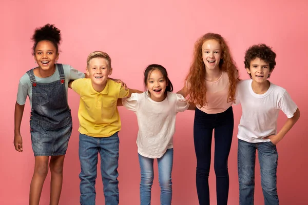 Porträtt av multietniska skolbarn ler på rosa bakgrund — Stockfoto