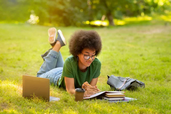 教育概念。年轻的黑人女学生带着书本和笔记本电脑在户外学习 — 图库照片