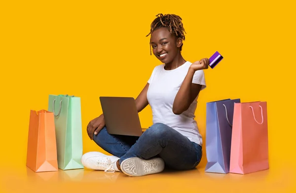 Positivo nero ragazza shopping online, utilizzando laptop e carta di credito — Foto Stock
