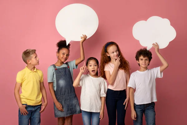 Estudantes multinacionais bonitos com bolhas de fala vazias sobre fundo rosa, espaço para design — Fotografia de Stock