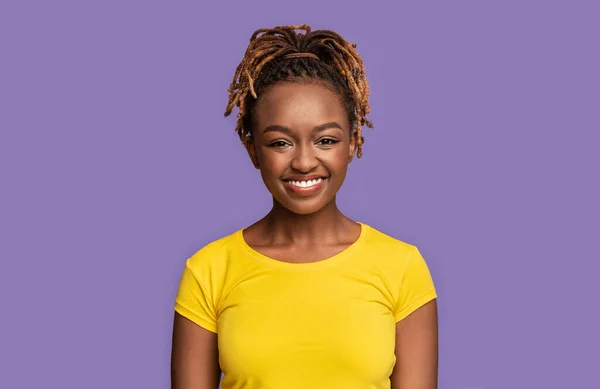 Jovem mulher negra bonita sorrindo no fundo roxo — Fotografia de Stock