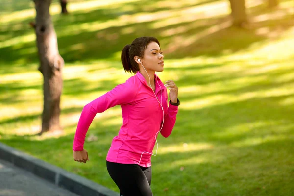 Vista lateral de la atlética mujer negra corriendo por el parque — Foto de Stock