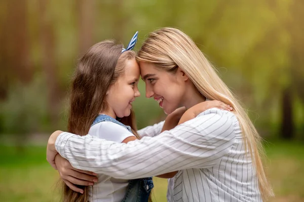 Kochająca mama Obejmująca małą córeczkę stojącą na zewnątrz w parku — Zdjęcie stockowe