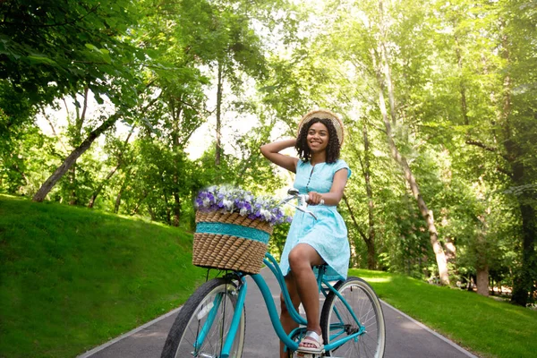 Retrato de mulher negra linda de bicicleta no parque no dia ensolarado de verão — Fotografia de Stock